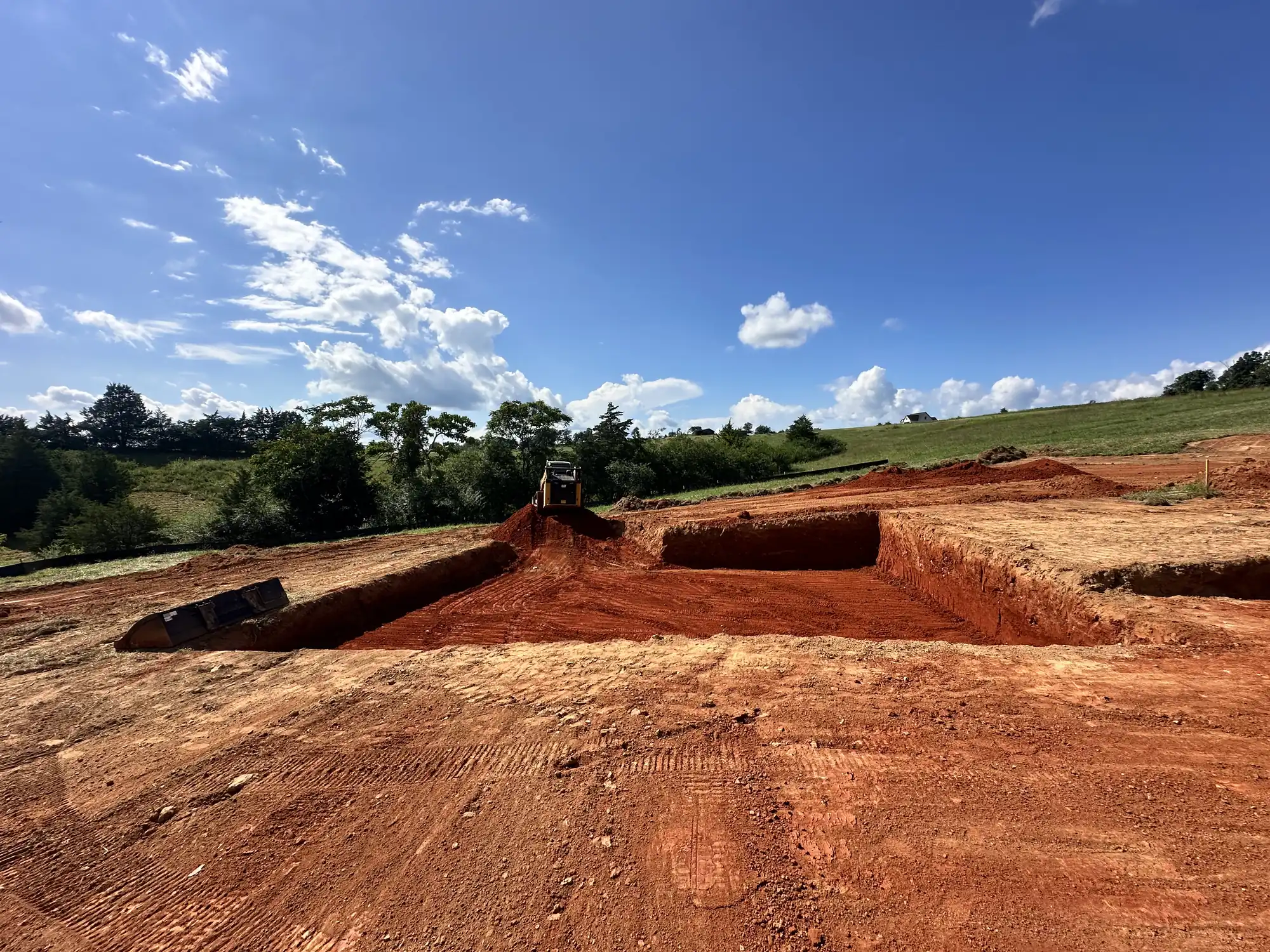 Tunstall's excavator performing foundation work on a residential site near Roanoke