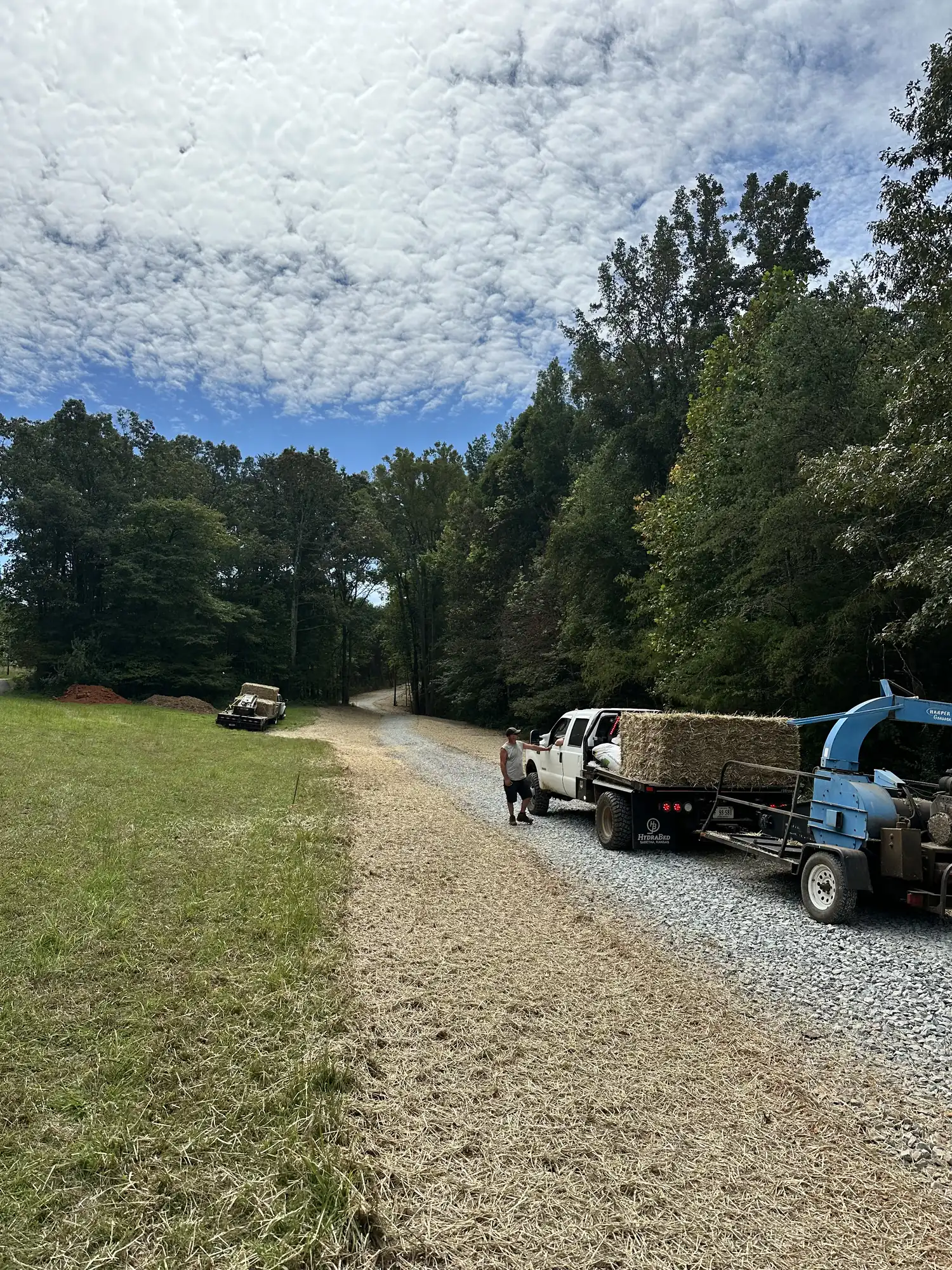 Gravel driveway with crew and straw blower equipment near Roanoke