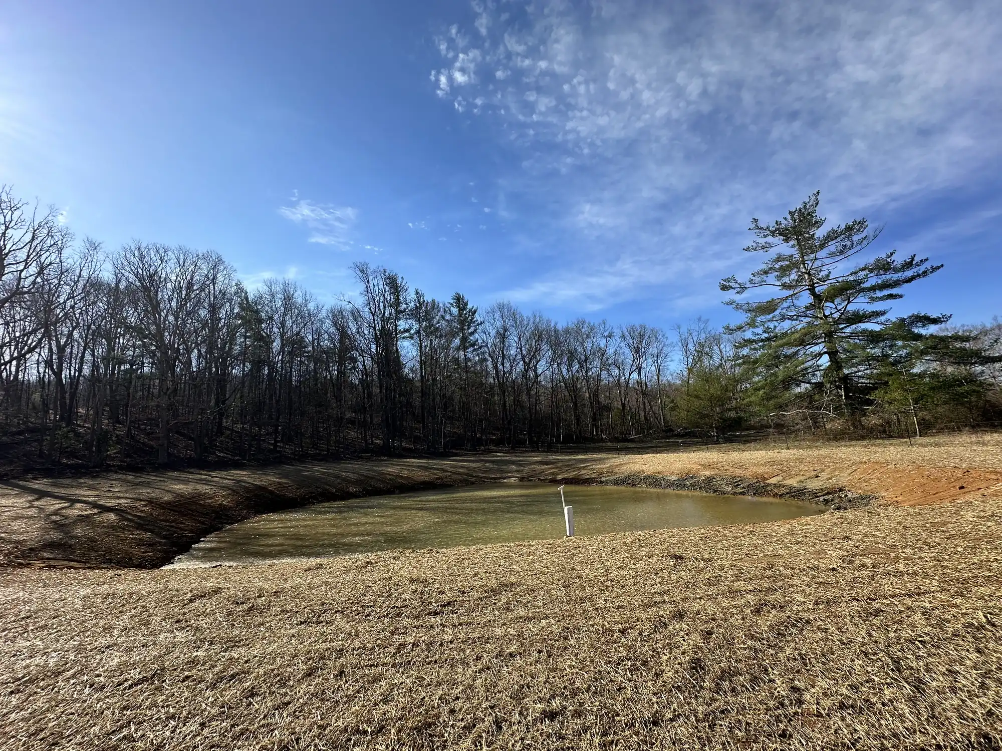 Finished retention pond with drainage channel near Roanoke